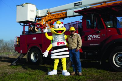 GVEC Louie the Lightening Bug & Lineman Posing in front of GVEC Truck