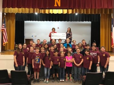 Presley, community relations representative from the Guadalupe Valley Electric Cooperative (GVEC), presents a $1,225.00 donation to Sarah White, FFA advisor and participants in the 2019 Nordheim Livestock Show, agriculture in the Guadalupe Valley