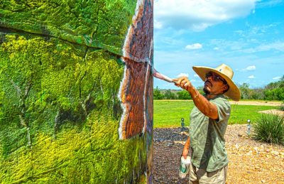 Picture of rafael acosta jr at work on a mural.