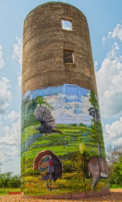 Wide-shot picture of a tower with a mural painted by rafael acosta jr, rafael acosta mural paintings