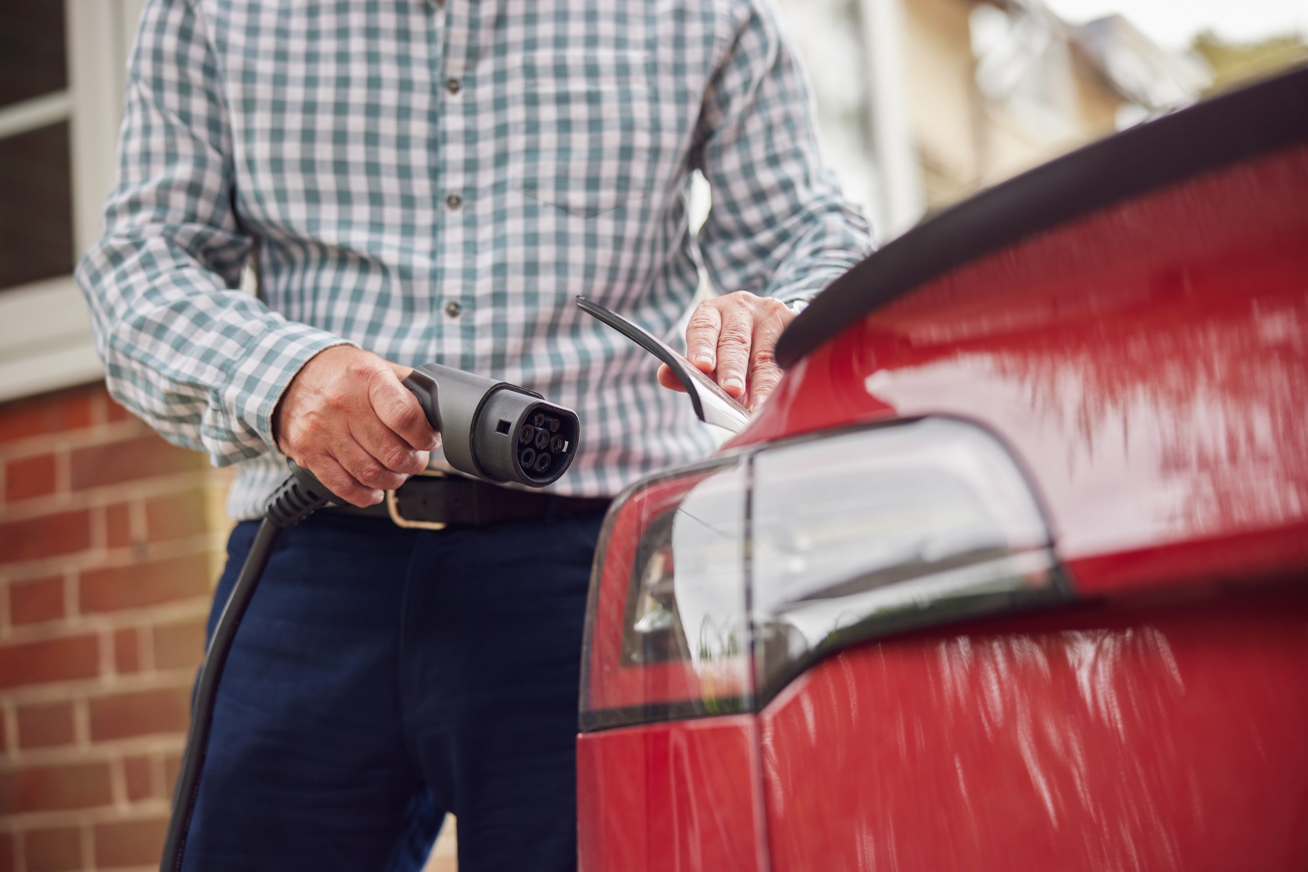 Man who has decided to drive electric plugging into his home charger