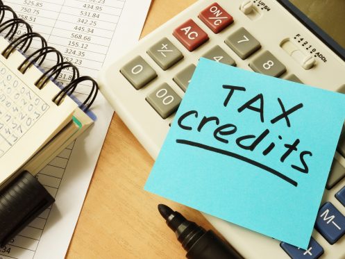 Notepad, calculator and note reading 'tax credits' depicting federal tax credits