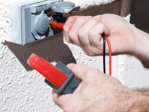 electrician checking voltage for home wiring inspections